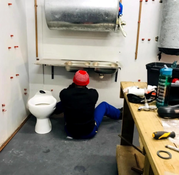 Residents learning practical skills through a plumbing artisan course.